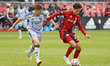 Preston Judd #19 of San Jose Earthquakes and Daniel Salloi #20 of Toronto FC compete for t...