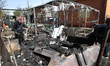 A man stands among debris in a yard affected by a Russian drone strike in Dnipro, Ukraine,...