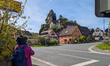 A woman stands beneath the towering Jura rock formations in the Rock Village Tuechersfeld,...