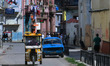 An electric tricycle and a classic American car are seen on a street in Havana, Cuba, on A...