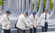 Korean War veterans examine stone monuments representing the 22 nations that fought alongs...