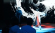 Tourists watch a dance performance of the UNITREE G1 humanoid robot at the Embodied Intell...