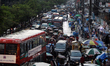 Vehicles move slowly through waterlogged streets in front of New Market in Dhaka, Banglade...