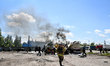 Rescuers extinguish burning tank trucks used by a private company to supply petrol station...