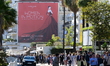 Tourists walk in the street in Cannes, France, during the 79th Cannes Film Festival on May...