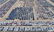 A large number of exported vehicles wait to be loaded onto ships at a car storage yard in...