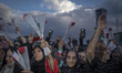 Pro-government supporters hold flowers as they participate in a mass wedding ceremony for...