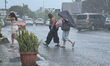 People walk in the town of Vaitape during a rainy day in Bora Bora, French Polynesia, on M...