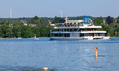 A woman with a dog cools off in the water of Lake Starnberg during hot summer weather in S...