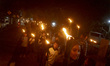 Muslim worshippers carry lit torches during a parade celebrating Eid al-Adha in Tanah Data...