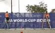Workers affix FIFA World Cup 2026 logos and signage at SoFi Stadium in Inglewood, Californ...