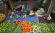 A vendor sells vegetables and waits for customers at a wholesale market in Kolkata, India,...