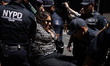 Members of the New York Police Department (NYPD) arrest climate activists from a coalition...