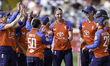 Freya Kemp of England (no cap, facing camera) is congratulated for taking a wicket during...