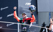 MotoGP race winners stand on the podium, including Marco Bezzecchi of Aprilia Racing, duri...