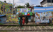 Women walk past billboards featuring photographs of the Argentina and Brazil football team...