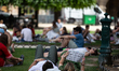A couple rests in the gardens of the Place des Vosges during a heatwave in Paris, France,...