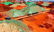 Construction machinery sorts and loads iron ore at the Qingdao Port ore terminal in Qingda...