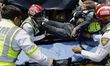 A female police officer receives treatment from paramedics after fainting as members of th...