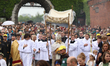 Participants in the Corpus Christi procession walk through the streets of Krakow, Poland,...