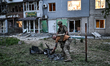 Law enforcement officers collect the wreckage of a drone in the Shevchenkivskyi district o...