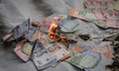 Students from the Indonesian Student Executive Board Alliance (BEM SI) burn mock banknotes...