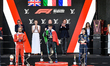 Isack Hadjar, Kimi Antonelli, and Lewis Hamilton celebrate on the final podium during the...