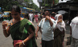 People cool off with a glass of cold water by the roadside amid a severe heatwave in Kolka...