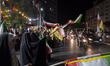Pro-government supporters wave Iranian national flags as they participate in a nightly ral...