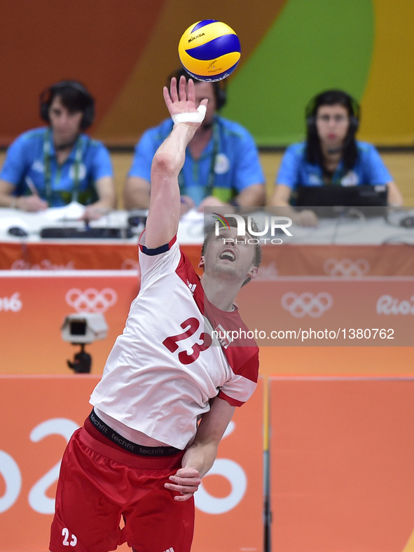 Poland 's Mateusz Bieniek serves the ball against Iran during a men's preliminary match of volleyball at the 2016 Rio Olympic Games in Rio d...