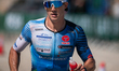 Filippo Candeo of Italy (race number M13) competes in the run leg past the historic walls...