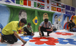 People decorate a lane with flags of participating nations, graffiti of famous footballers...