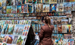 A tourist photograph a wall with paintings in landmark Barbican in central Krakow, Poland...