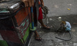 A traditional street entertainment group performs Topeng Monyet, a monkey mask show, with...