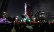 People gather at the Monument of Angel of Independence to celebrate Mexico's victory over...