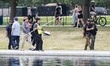 U.S. National Park Service workers, accompanied by a police escort, test the water after a...