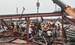Disaster management teams, firefighters, and army personnel work to rescue trapped workers...