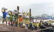 Workers balance large ice-packed fish bags on their heads as they step off a traditional w...