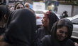 Iranian women wait to receive donated meals while participating in Tasua commemorations ne...