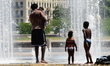 A family cools off in the fountain at Place Antonin Poncet in Lyon, France, on June 25, 20...