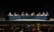 People in the theater take their seats as members of the Rent Guidelines Board take the st...