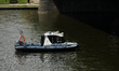 A police boat sails down the Vistula River during the 15th Water Critical Mass in Krakow,...