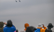 IWAKUNI, JAPAN - MAY 3: 
Airshow spectators wearing rain jackets and protective hoods loo...