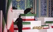 An unidentified man adjusts a coffin during a ceremony honoring the remains of Iran's late...