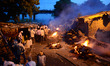Indian people stand near roadside cremations following heavy flooding in Ganges River , in...