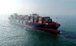 A cargo ship loaded with foreign trade containers sails towards the open sea in the Jiaozh...