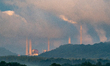 Heavy haze and humidity are visible as pollution and steam rise from the stacks of the Mia...