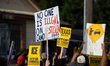 A sign reads, ''No one is illegal on stolen land!'' during a vigil and demonstration at th...