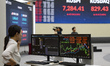 A Korea Exchange (KRX) employee monitors stock market data on trading screens inside the K...