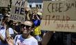Activists hold handmade cardboard placards during a spontaneous protest after President Vo...